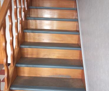 Escalier rénové avec des marches en PVC et des finitions soignées